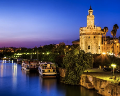 Mudarse a Sevilla: 8 Razones por las que trasladarse a Sevilla Mudarse a Sevilla - Panorámica de Sevilla de noche con la Torre del Oro