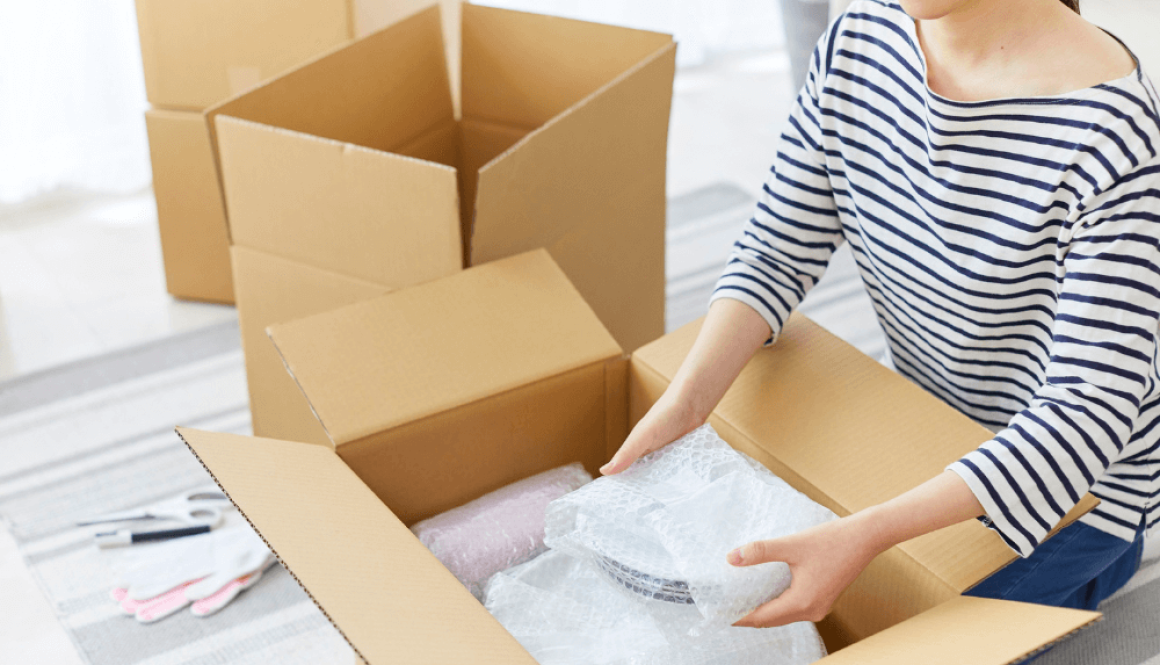 woman storing crockery in moving box