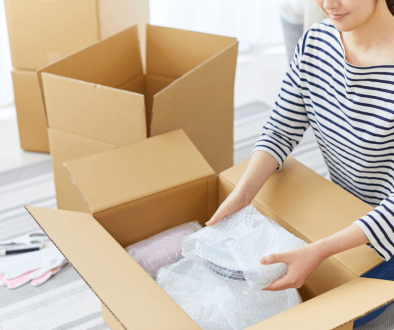 woman storing crockery in moving box