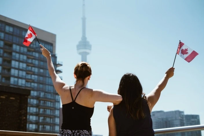 Mudarse a Toronto - Mujeres con la bandera de Canadá